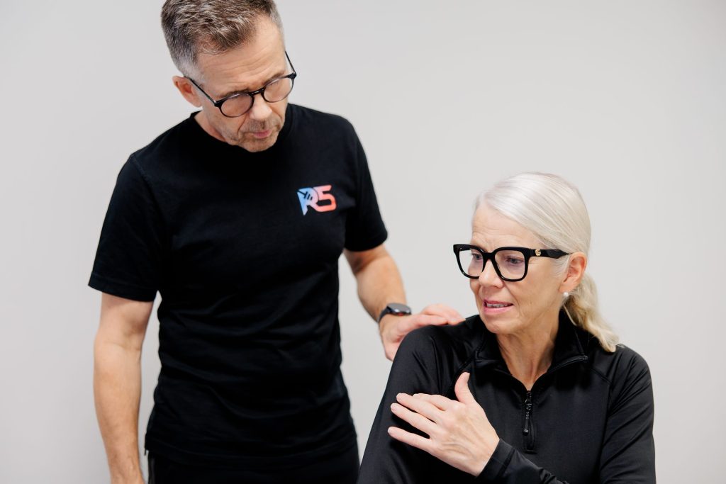 Osteopaatti Jerry Ketola tutkii asiakkaan olkapäätä