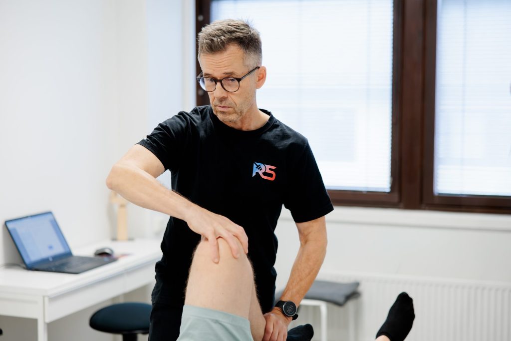 Osteopaatti Jerry Ketola tutkii asiakkaan polvea vastaanotolla Helsingin Metsälässä
