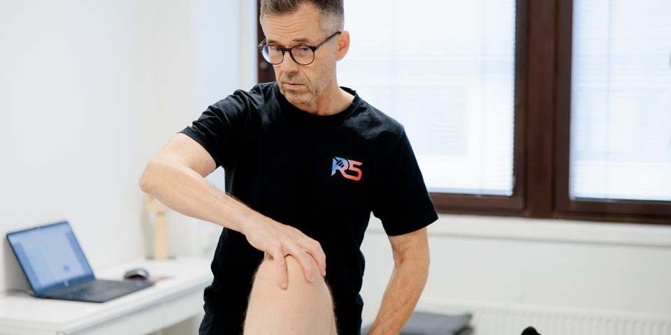 Osteopaatti Jerry Ketola tutkii asiakkaan polvea vastaanotolla Helsingin Metsälässä
