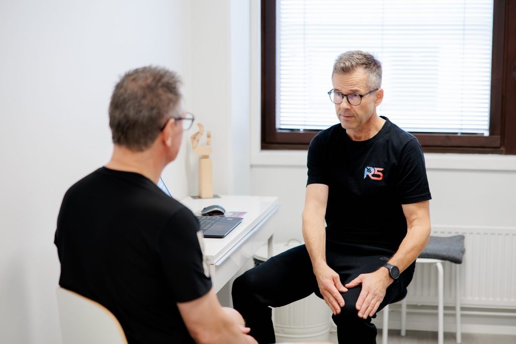 Osteopaatti Jerry Ketola keskustelee asiakkaan kanssa vastaanotolla
