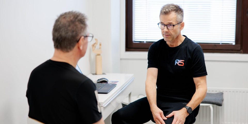 Osteopaatti Jerry Ketola keskustelee asiakkaan kanssa vastaanotolla