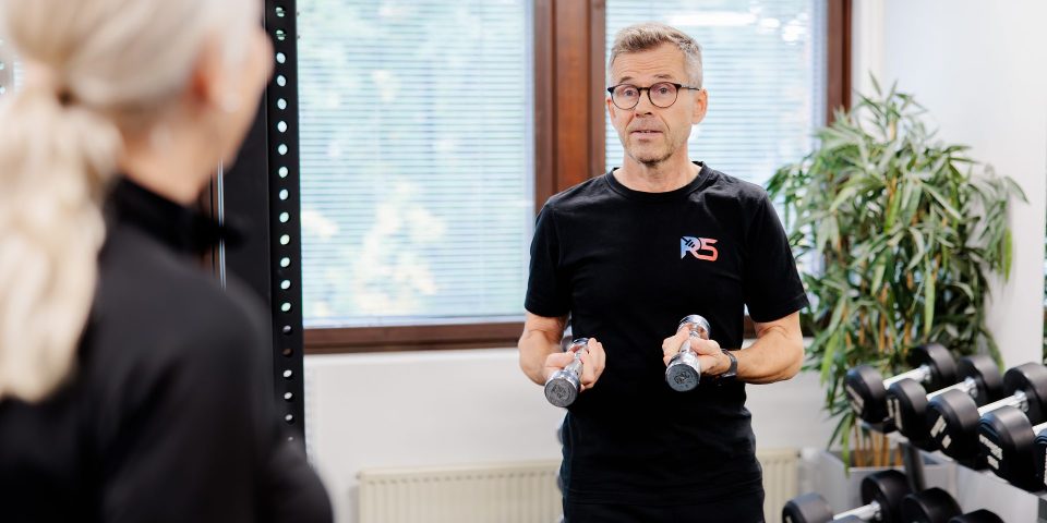 Personal trainer Jerry Ketola neuvoo asiakasta käsipainoharjoittelussa kuntosalilla