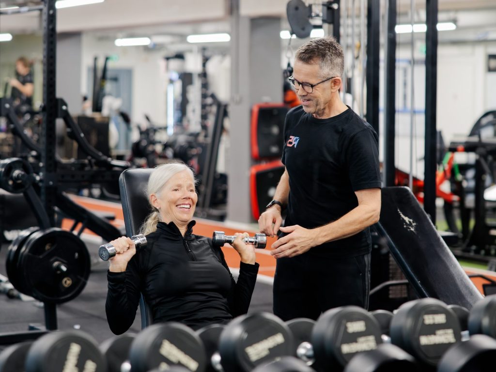 Personal trainer Jerry Ketola ohjaa asiakasta käsipainoharjoituksessa R5-kuntosalilla Metsälässä