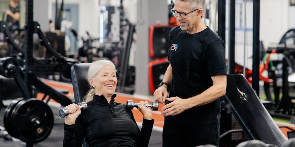 Personal trainer Jerry Ketola ohjaa asiakasta käsipainoharjoituksessa R5-kuntosalilla Metsälässä